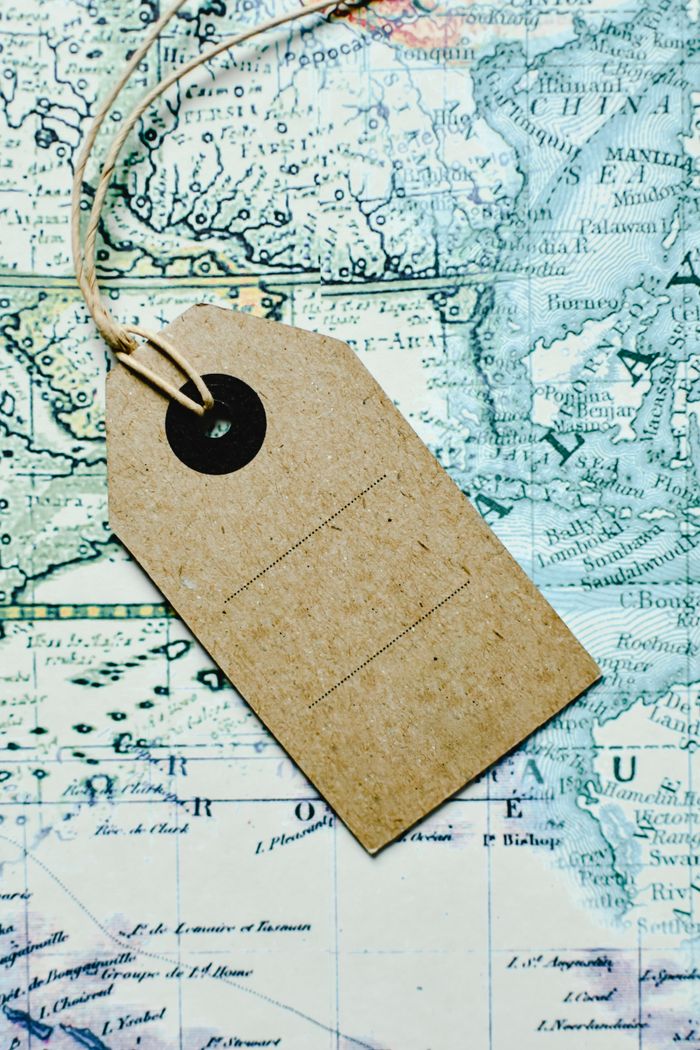our-story Brown paper tag placed on a vintage map, representing travel and exploration themes.
